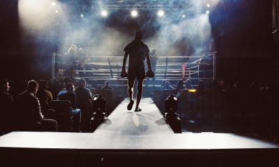 man standing and walking going on boxing ring surrounded with people