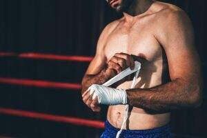 Boxing athlete men wrapping hand with boxing tape before wearing boxing gloves at gym