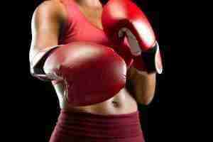 Close up of black woman boxer kicking camera
