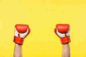 close-up partial view of person in boxing gloves isolated on yellow