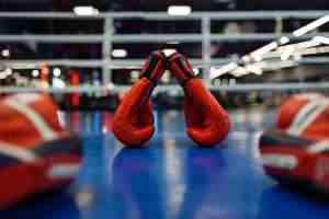 Pair of red boxing gloves and pads on ring, nobody