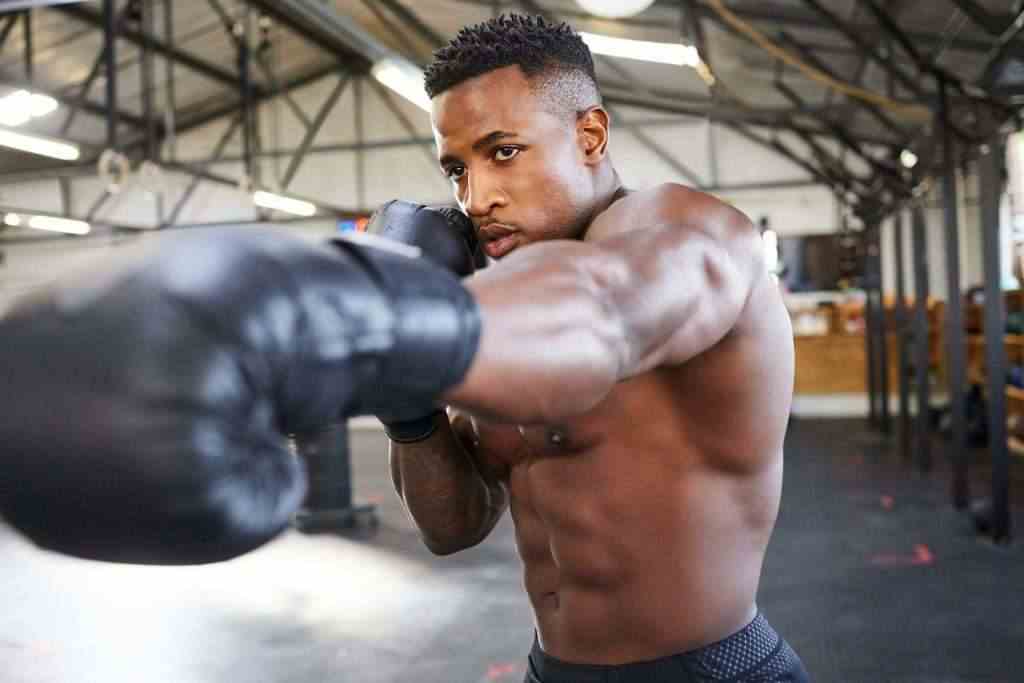 Shot of a muscular young man wearing boxing gloves in a gym