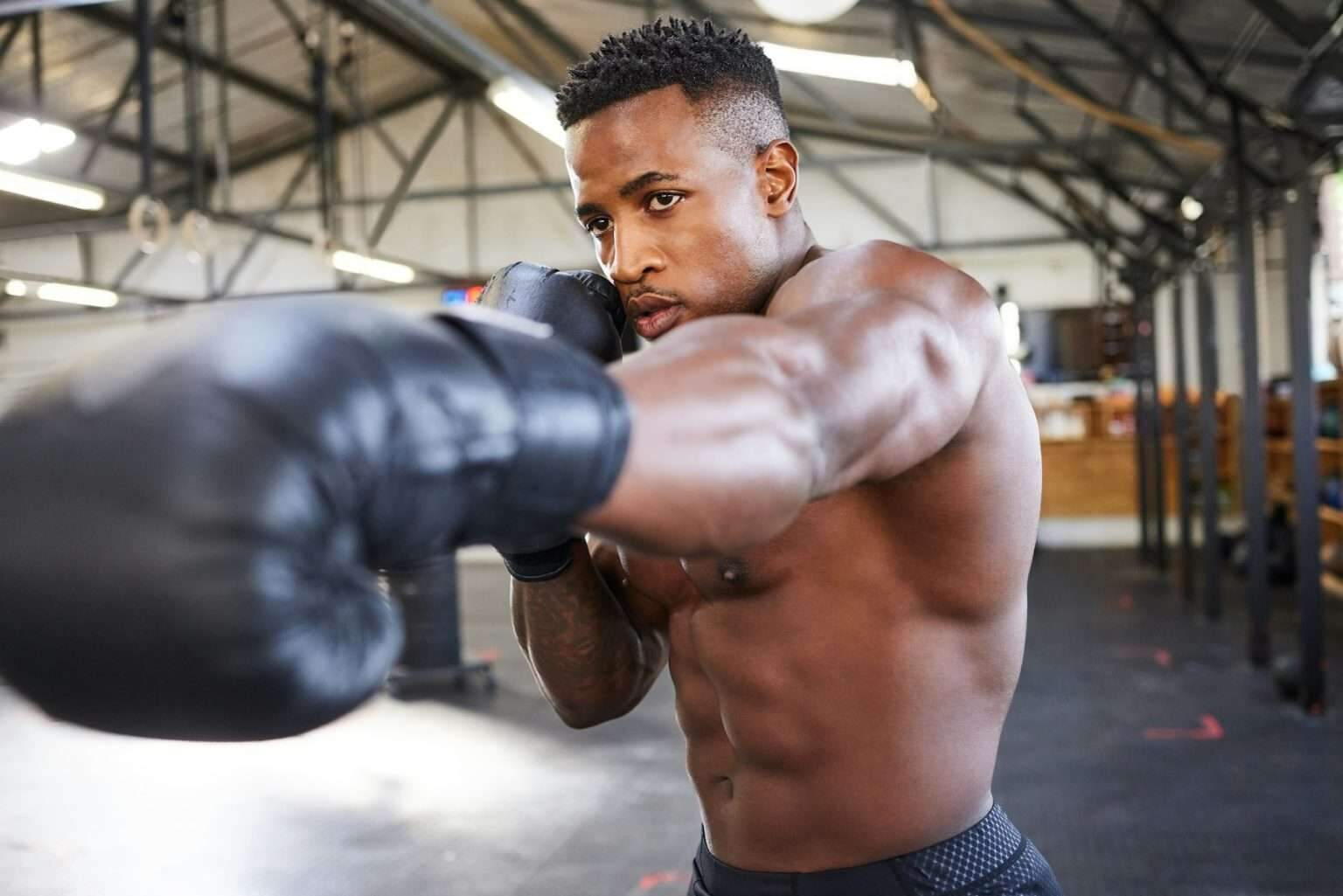 Shot of a muscular young man wearing boxing gloves in a gym