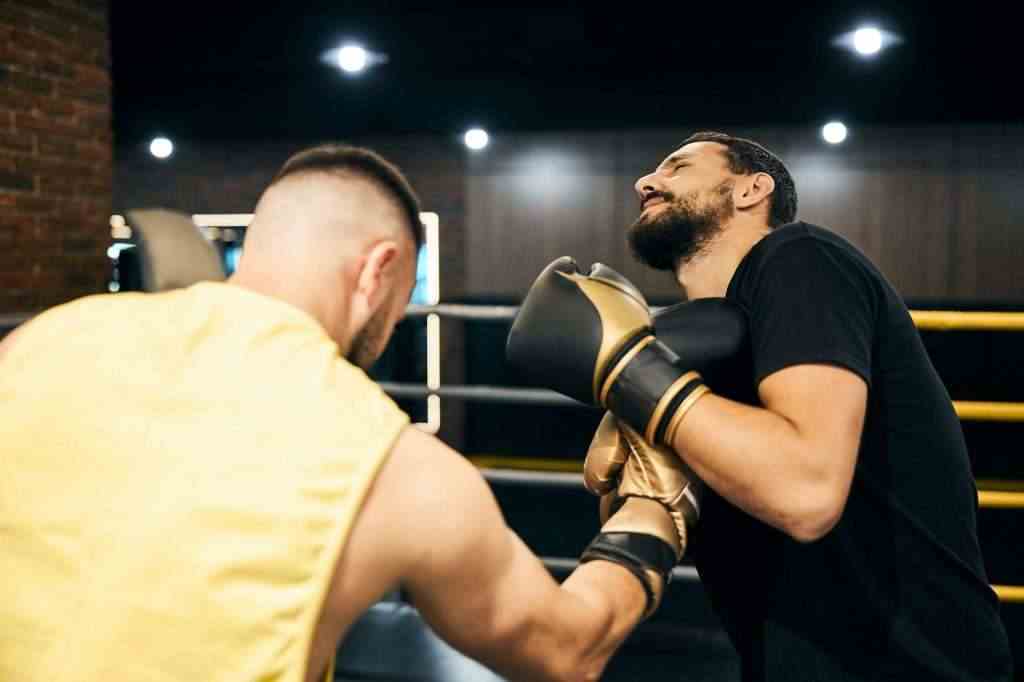 Boxer hitting his sparring partner with an uppercut