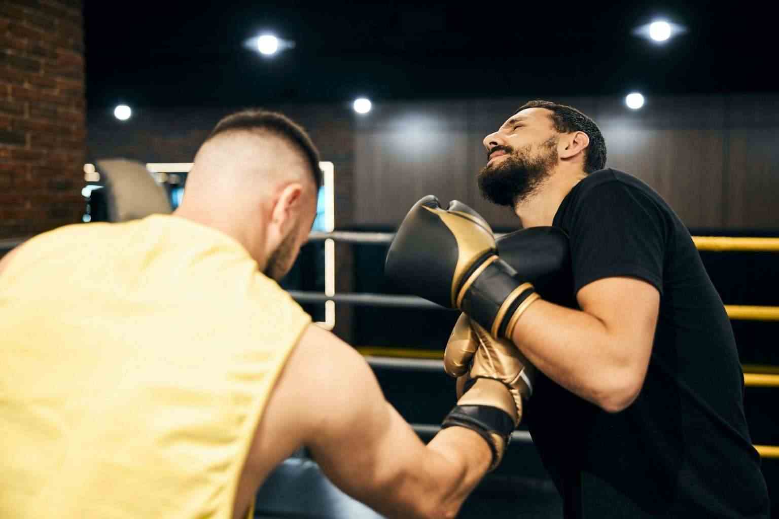 Boxer hitting his sparring partner with an uppercut