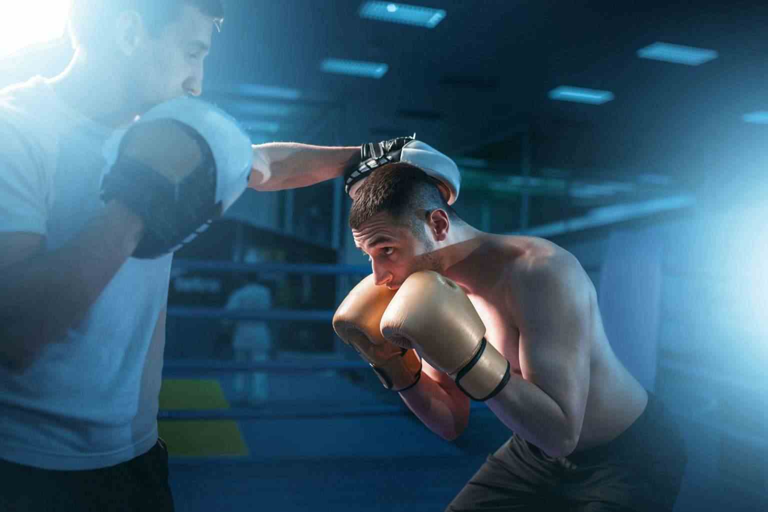 Combat de Boxe : 20 Étapes pour se Préparer Efficacement Boxer in gloves exercises with sparring partner