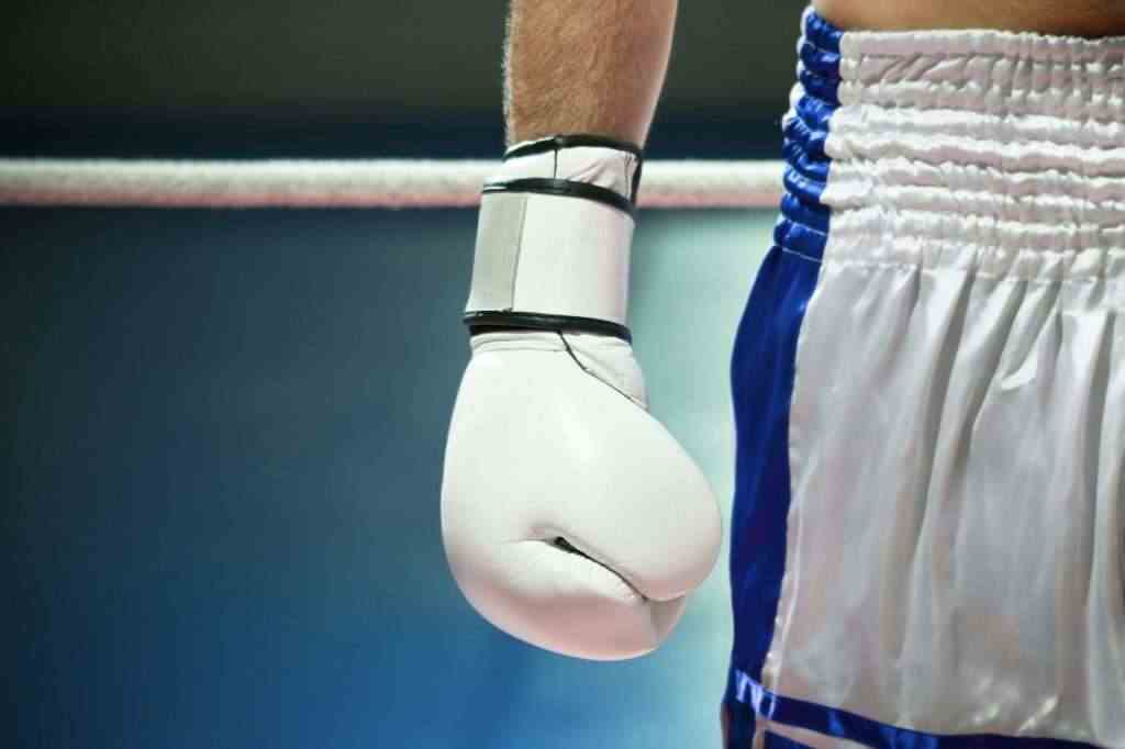 Closeup Of Boxing Gloves With Boxer Athlete On Ring