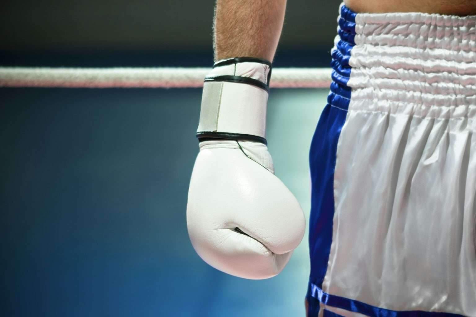 Closeup Of Boxing Gloves With Boxer Athlete On Ring