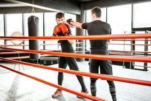 Man training with boxing coach on the boxing ring
