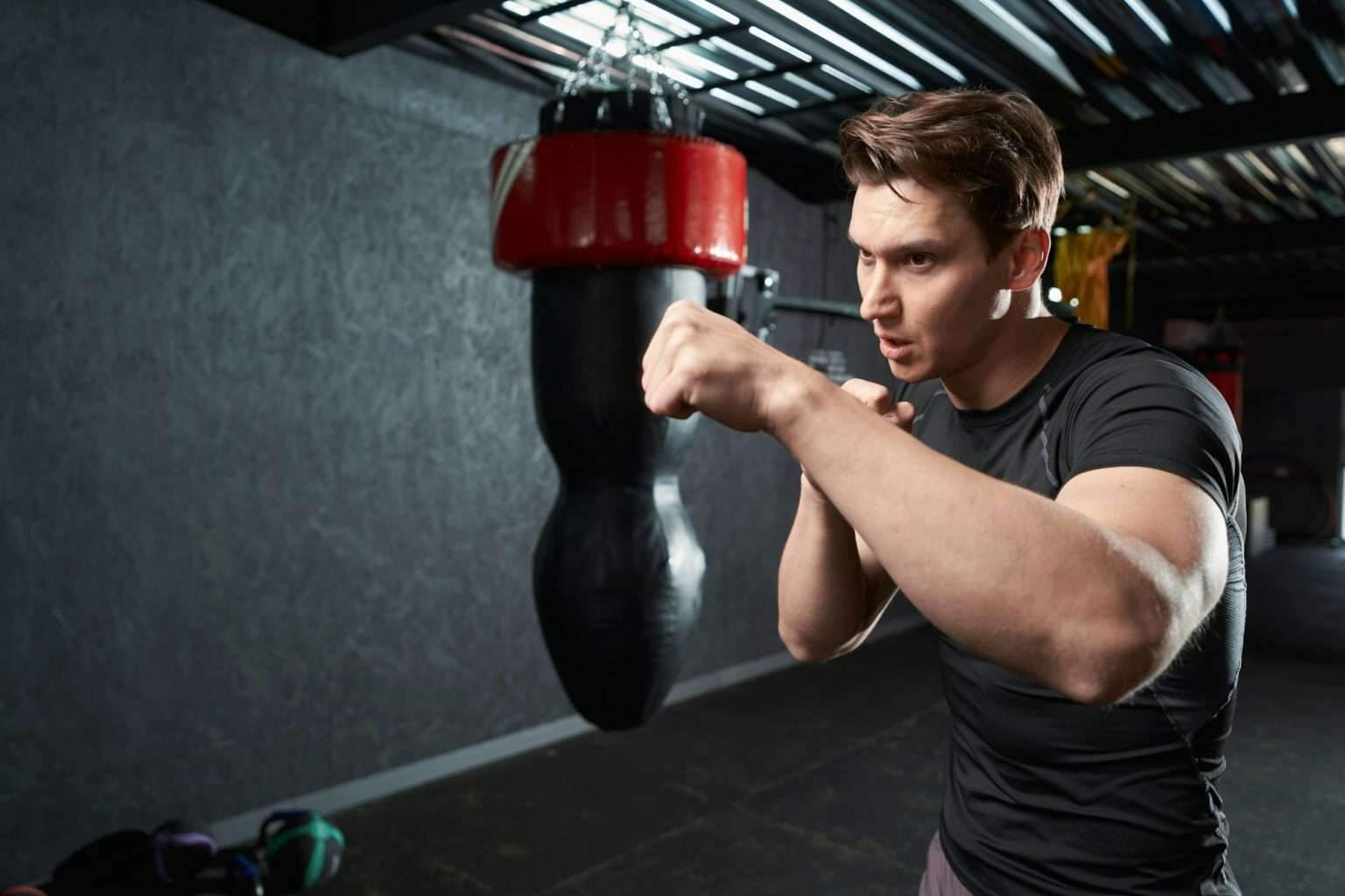 Shadow boxing : les bases pour progresser rapidement Serious focused male boxer shadow-boxing at gym