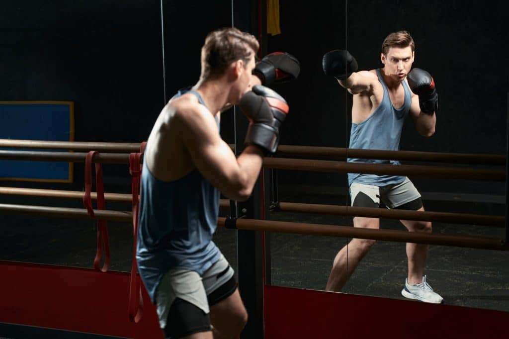 Professional sportsman in boxing gloves practicing jabs