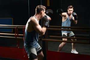 Professional sportsman in boxing gloves practicing jabs